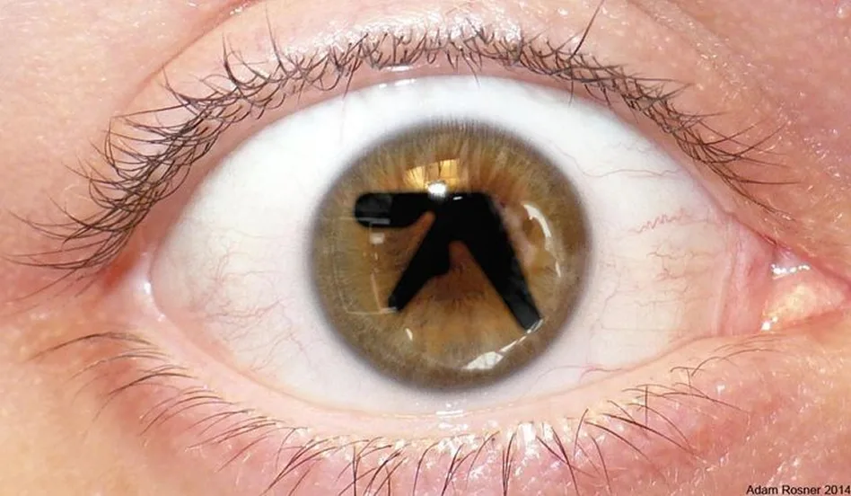 Aphex-a-like. 갈색 눈동자 한가운데 Aphex Twin 로고가 비친 눈 클로즈업