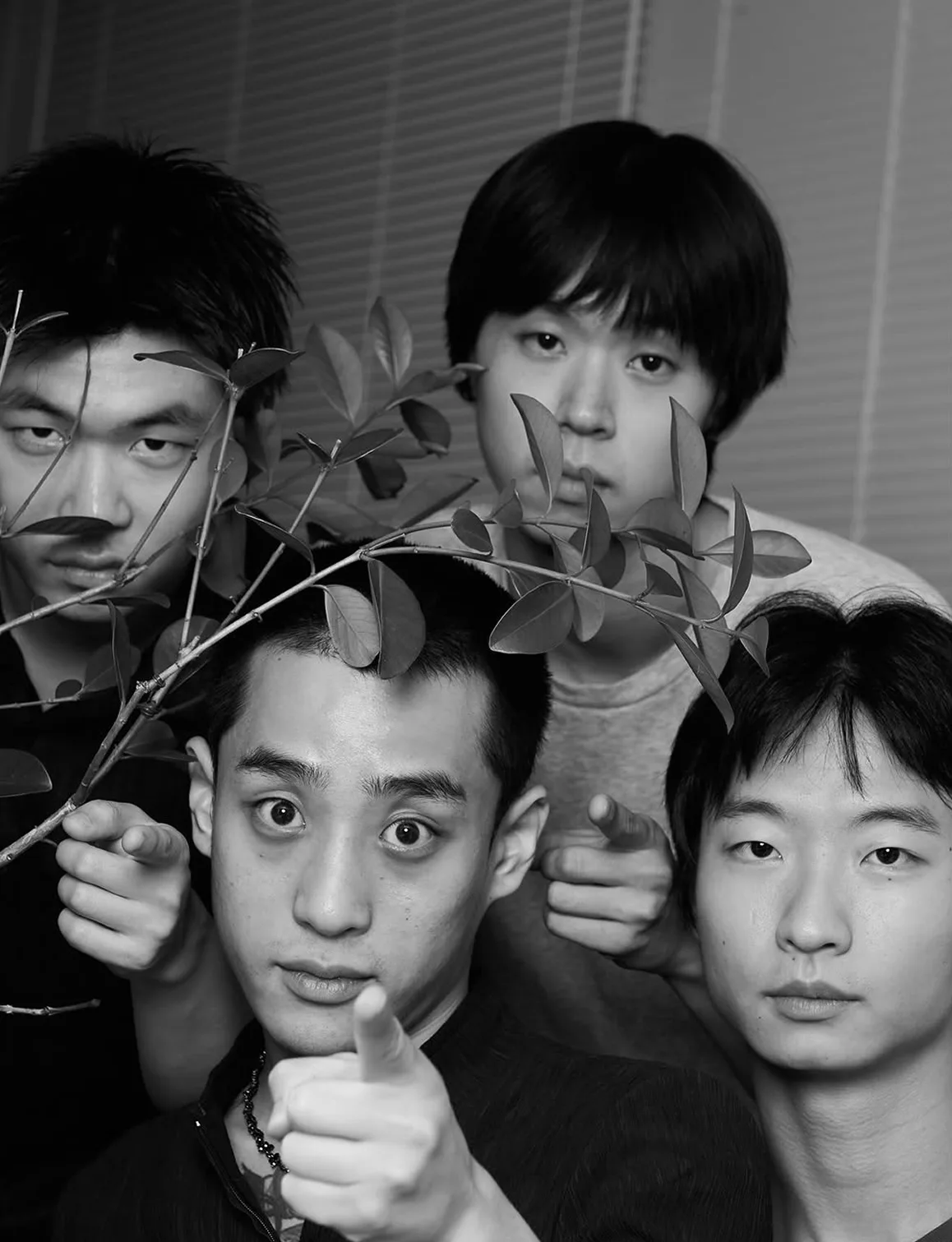 HERV 네 사람이 한데 모인 흑백 사진. 맨 앞 사람이 카메라를 손가락으로 가리키고, 뒤쪽 사람은 잎이 달린 나뭇가지를 들고 있다