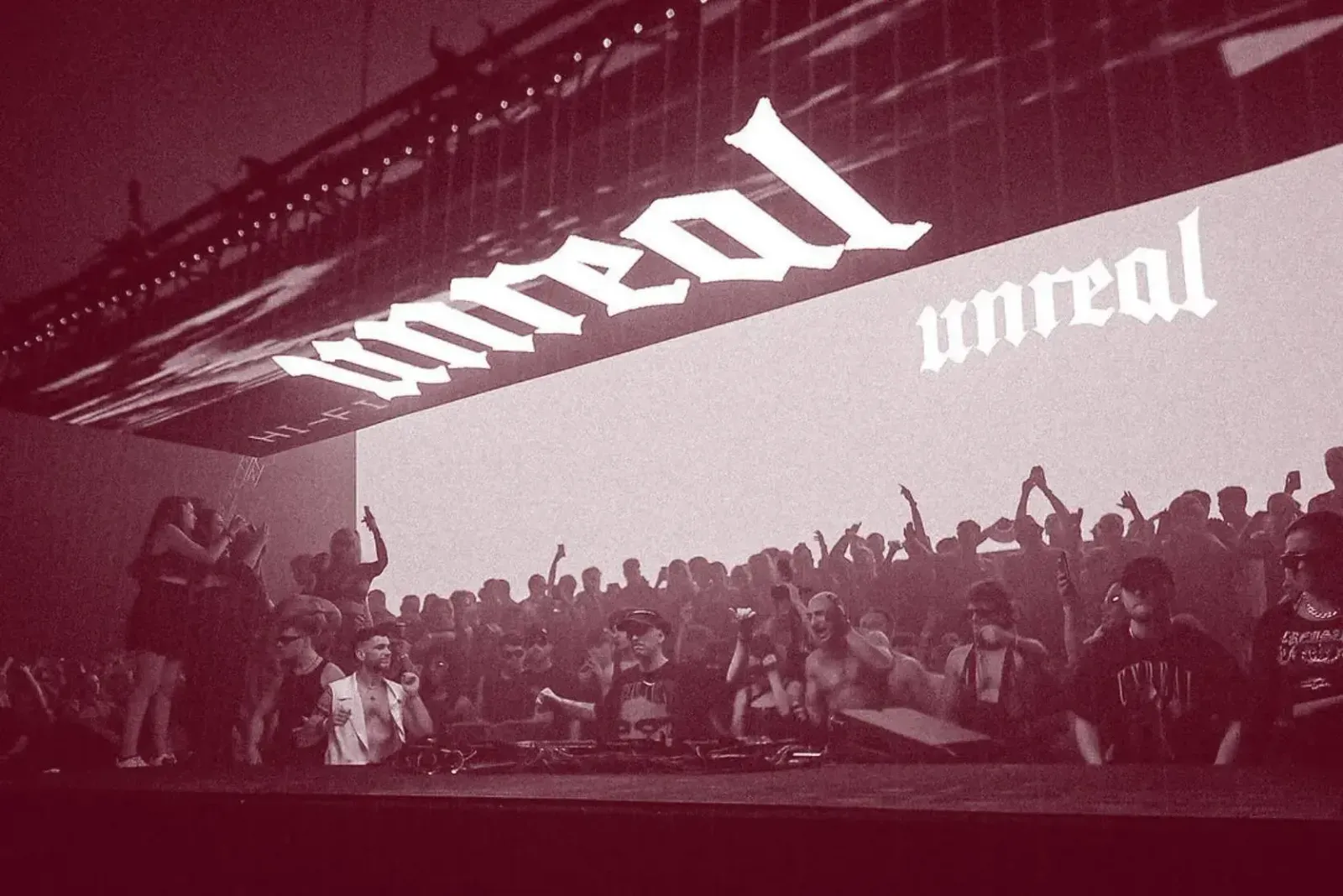 Unreal 로고가 보이는 무대의 디제이 부스와 그 뒤에 모인 관객